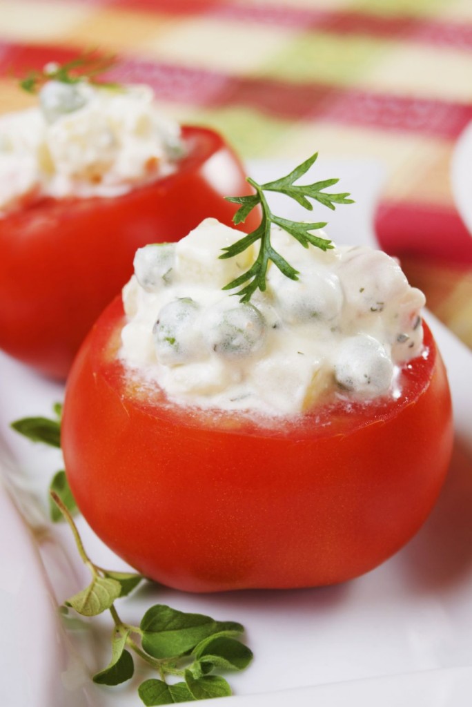 Fresh tomato stuffed with vegetable and sour cream sauce